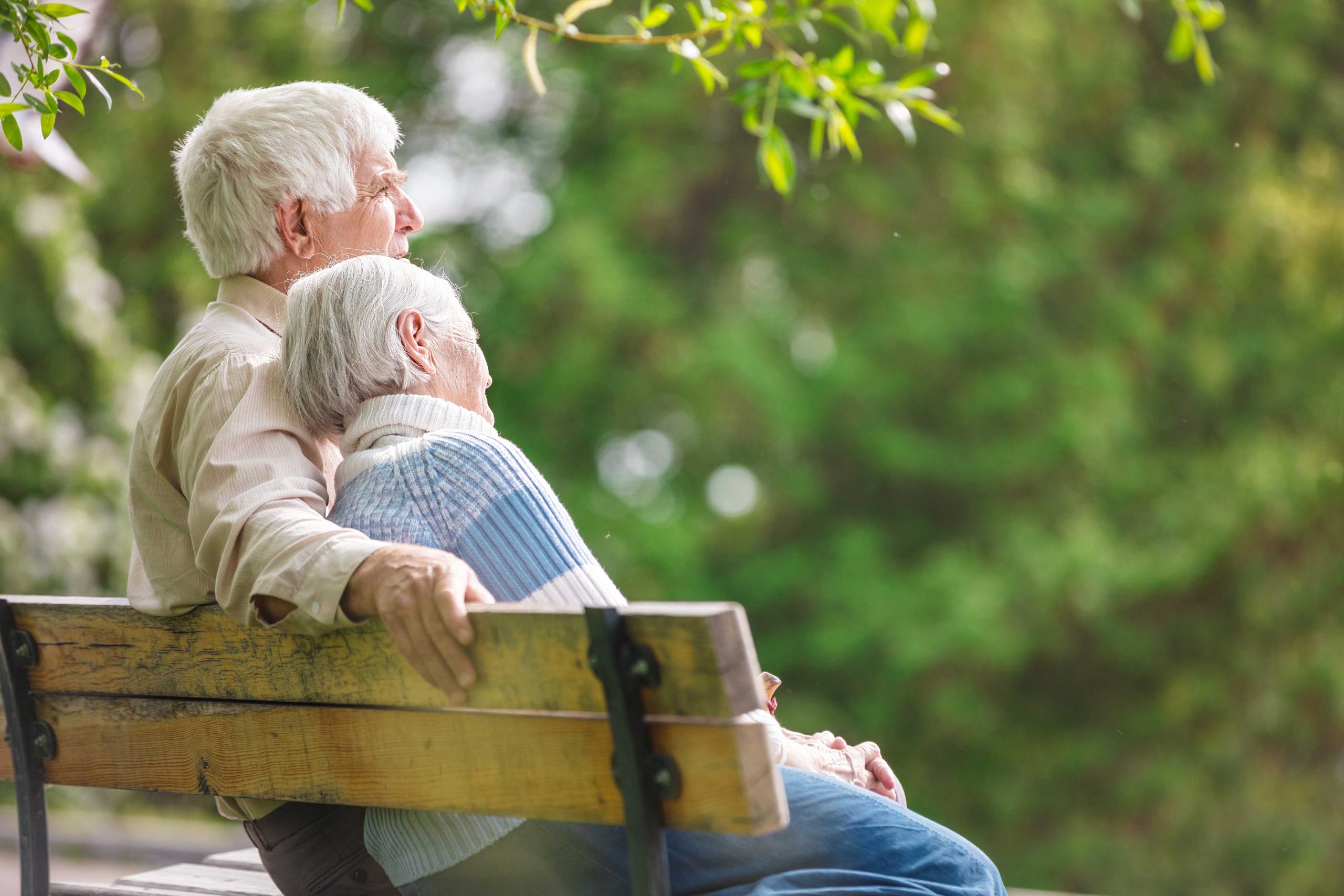 Seniors couple sitting on bench outside