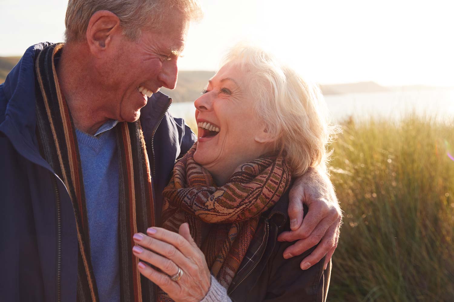 happy senior couple by the water