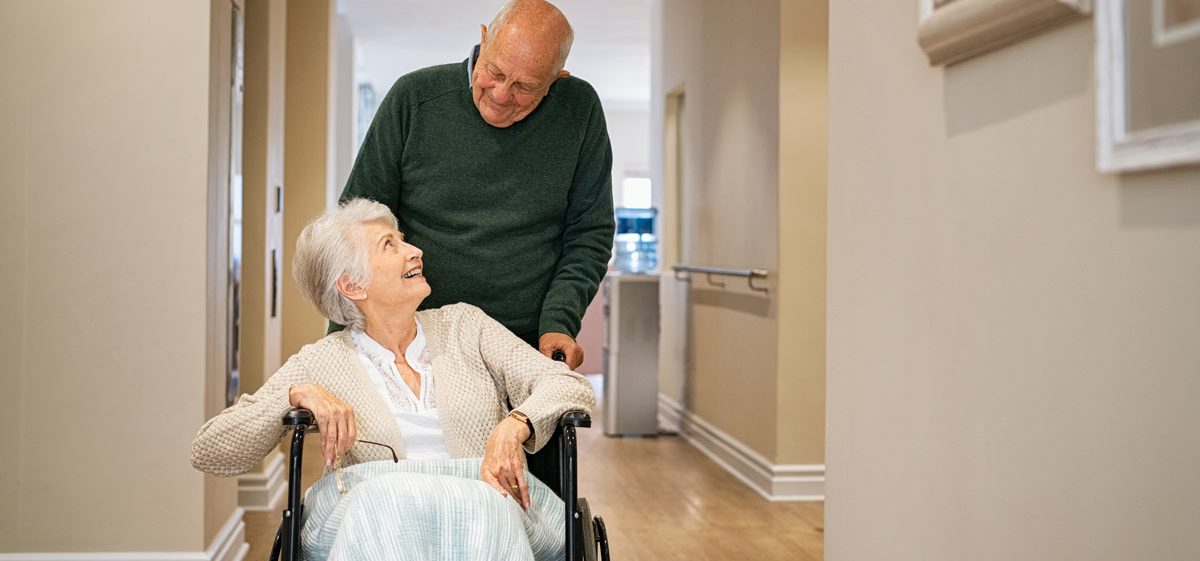 VRS Ross Place senior man visiting disabled woman on wheelchair at nursing home