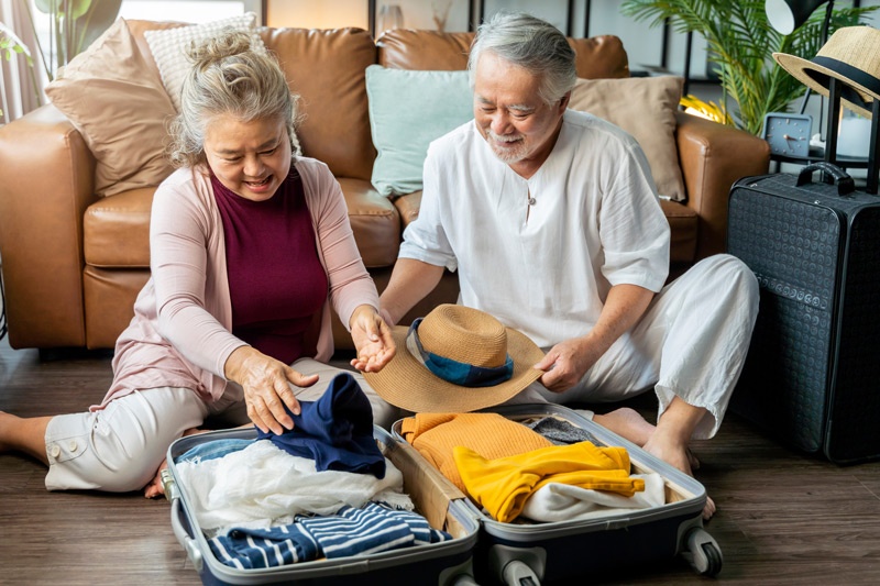 Senior Couple Packing Vacation Suitcase at Retirement Home in Victoria