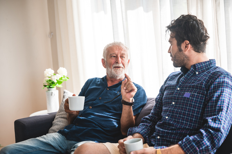 Senior telling story to son at a retirement home in Victoria