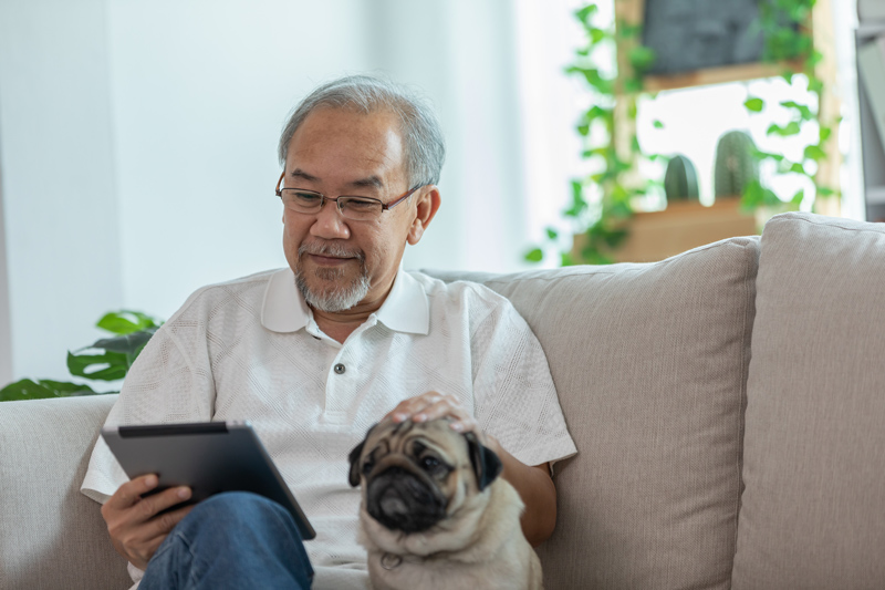 Senior on iPad tablet with dog at VRS retirement home in Victoria