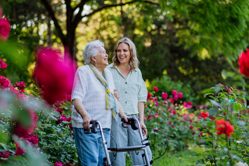 Senior safely walking outside with a walker at a senior independent or assisted living community in Victoria